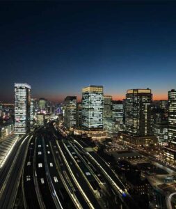 ホテルメトロポリタン 丸の内の室内からみた東京駅周辺の夜景とビル群、線路を走る新幹線