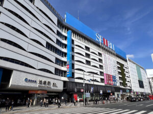 晴天の池袋駅東口駅前広場と西武池袋本店の大型ビル
